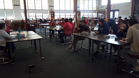 Varsity Scholastic teams face off on November 28, 2018. Bayside's team is in red, on the left, and Kempsville's team is on the right. The judge and timekeeper sit in a table in front.