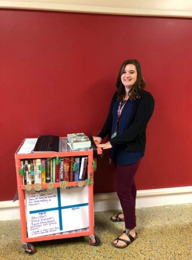  Ms. Taylor Guckert with her classroom in a cart.  She doesnt have an assigned classroom because she is a floater teacher, but that doesnt keep her from carrying books around. 
