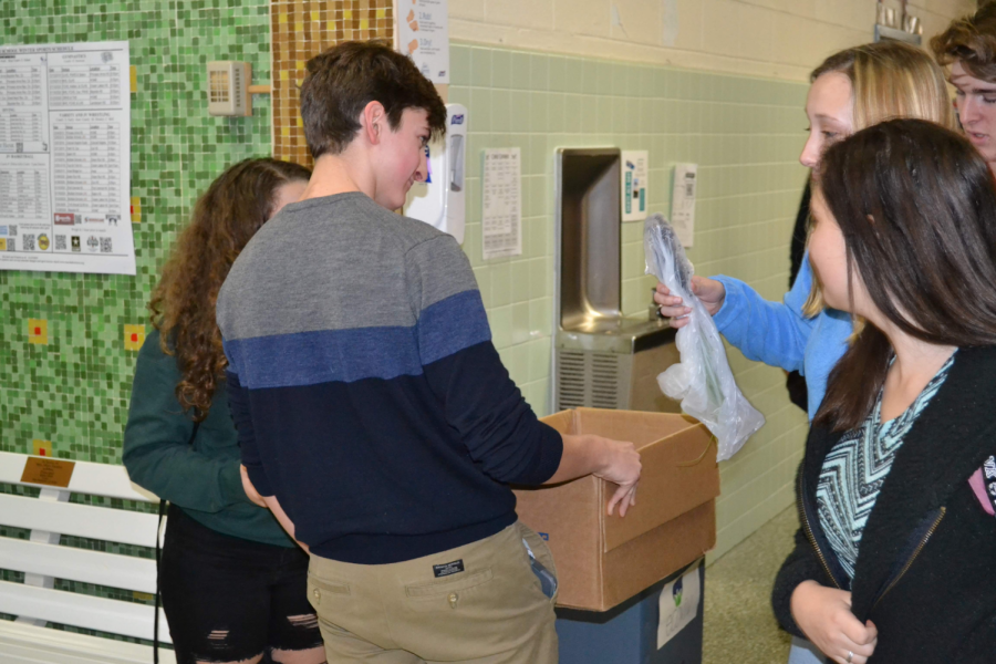 Evan Nied handing out saplings to departing Kempsville students at the end of the day on December 13 as part of his Planting Shade mission