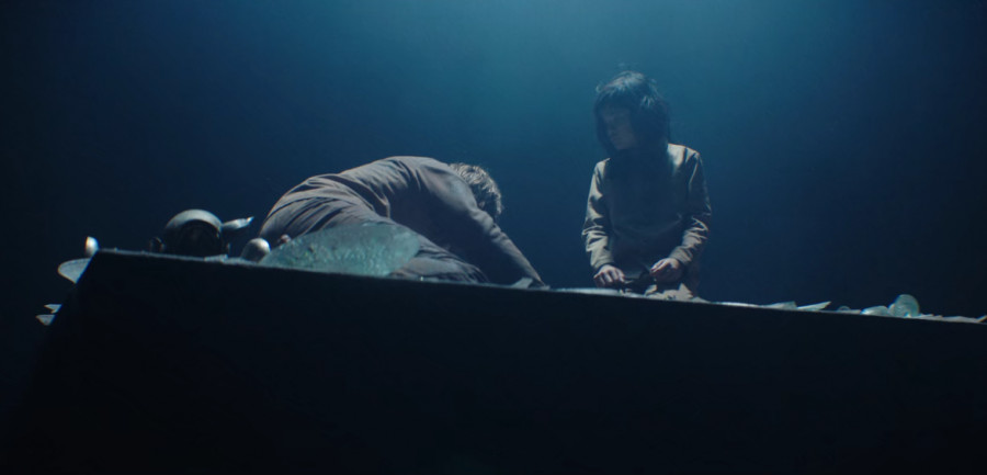 The slab descends into a purgatory-like area amidst a beam of light. Goreng, played by Iván Massagué, is collapsed on the left.. Zihara Llana, who played the girl, is on the right. 